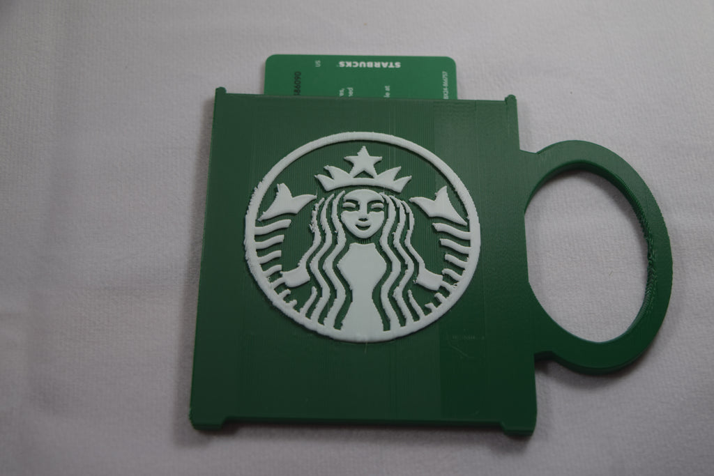 Starbucks mug gift card holder, green 3D-printed plastic with white Starbucks logo and card visible.