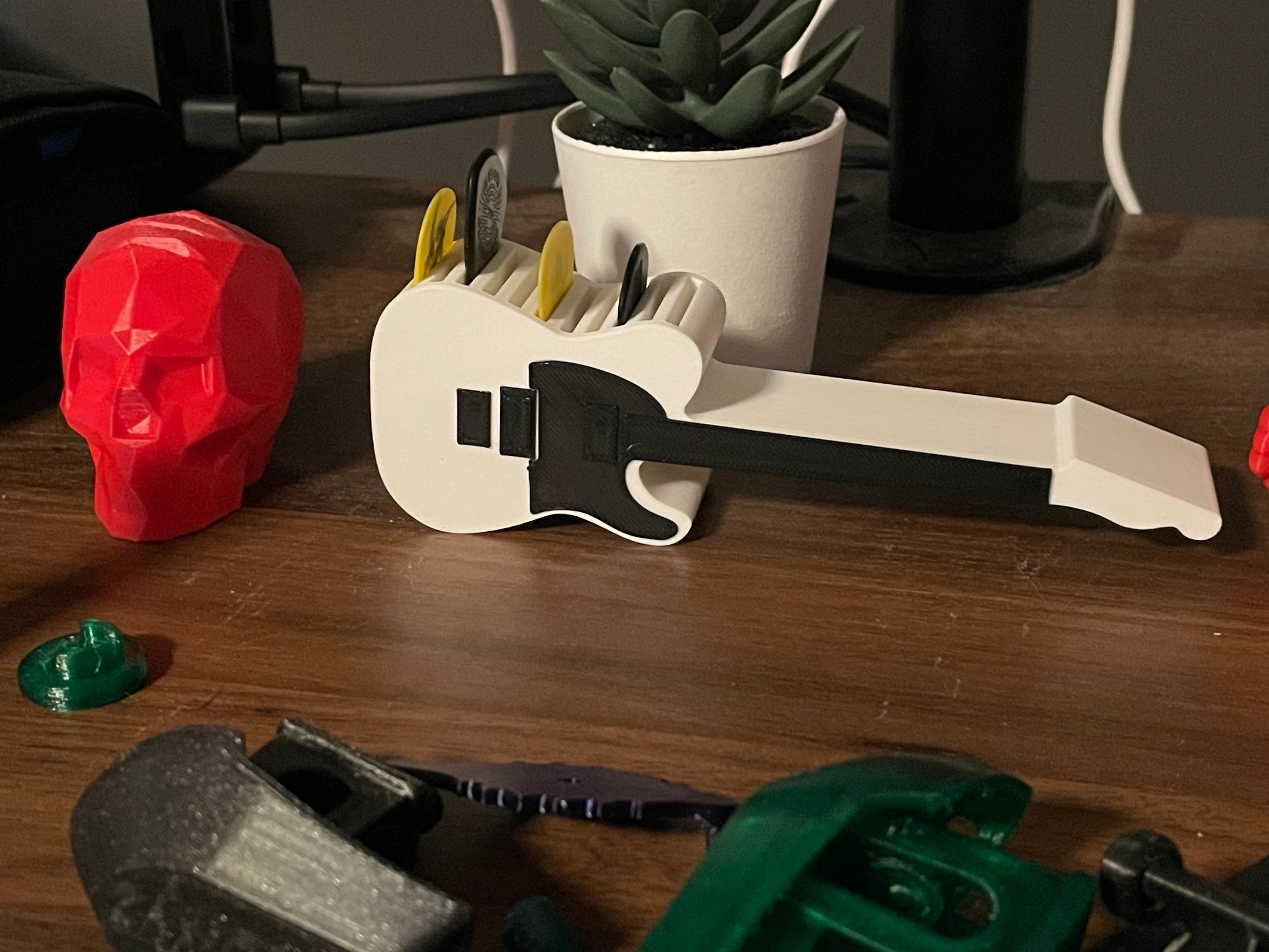 Telecaster-style guitar pick holder in white plastic, holds 4 picks