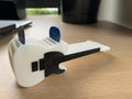 Telecaster-style guitar pick holder, white 3D-printed body with a black clamp, holding two picks (blue and gray)